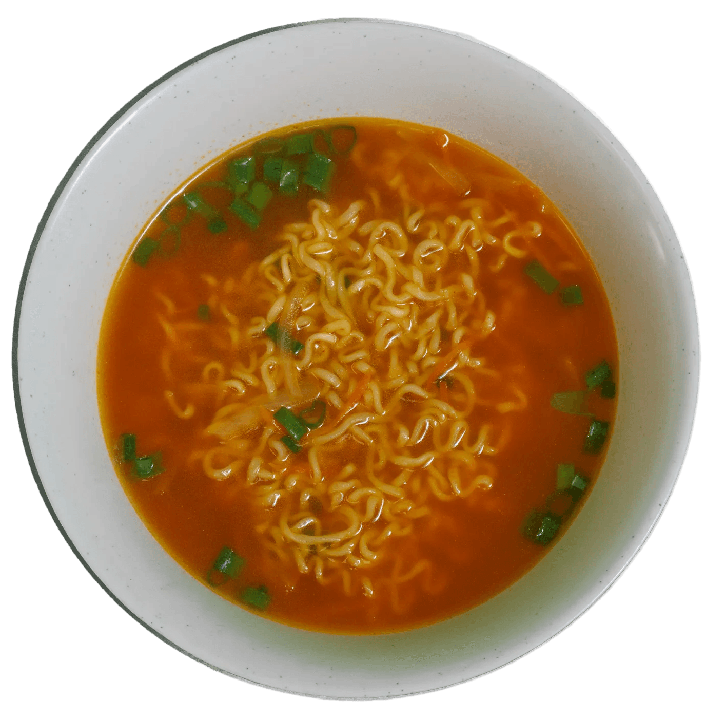Overhead view of a white bowl filled with instant ramen in a reddish-orange broth, garnished with chopped green onions.