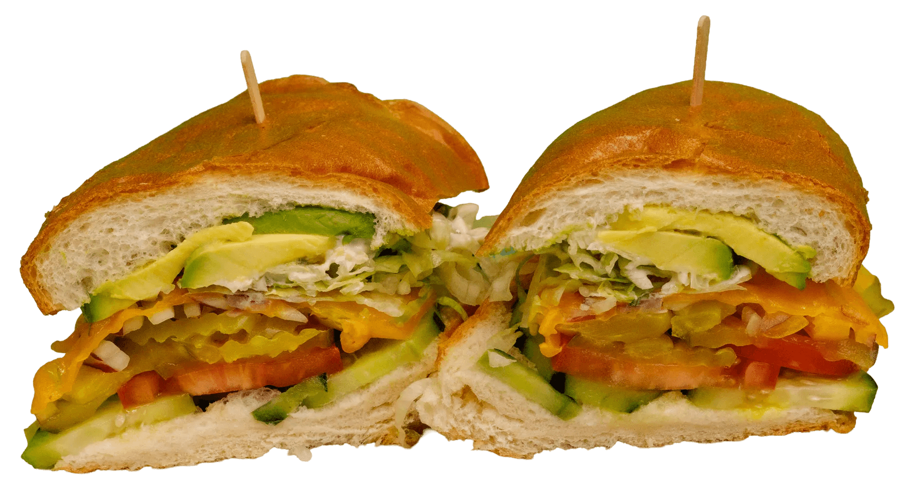 A hearty sandwich, cut in half, revealing layers of avocado, shredded lettuce, yellow peppers, red onion, tomato, and cucumber on a golden toasted bun.